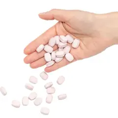 En hand håller rosa tabletter, som kan symbolisera nackdelar med betablockerare.