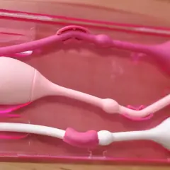 Tre knipkulor i rosa och vitt, förberedda för användning, kanske för en gravid kvinna som vill stärka bäckenbotten.