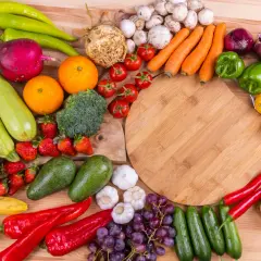 En färgsprakande samling frukter och grönsaker, som paprika, tomater, apelsiner och jordgubbar, som kan hjälpa mot c vitamin brist.