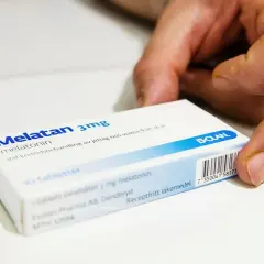 En hand håller i en kartong med Melatan 3mg melatonin. Detta receptfritt läkemedel kan hjälpa mot jetlag.