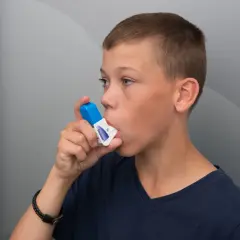 Pojke använder inhalator. Tänk på att vape farligt kan påverka lungorna.
