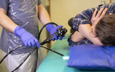 Läkare med blå handskar förbereder en endoskopi på en patient.