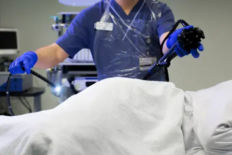 Läkare utför en endoskopi av tjocktarmen med ett flexibelt instrument.