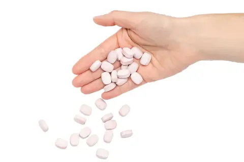 En hand håller rosa tabletter, som kan symbolisera nackdelar med betablockerare.