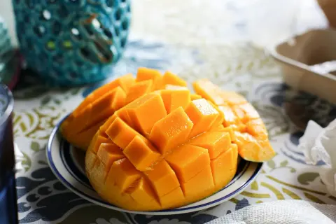 Skivad mango på en tallrik, en tropisk frukt rik på vitamin A.