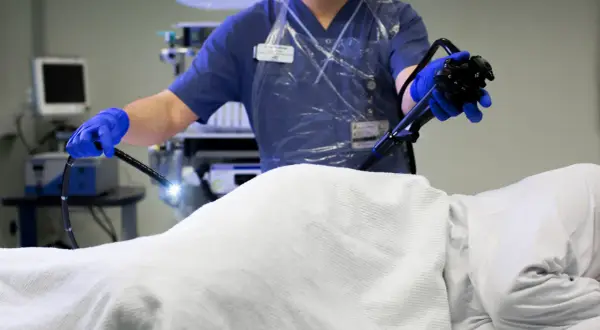 Läkare utför en endoskopi av tjocktarmen med ett flexibelt instrument.
