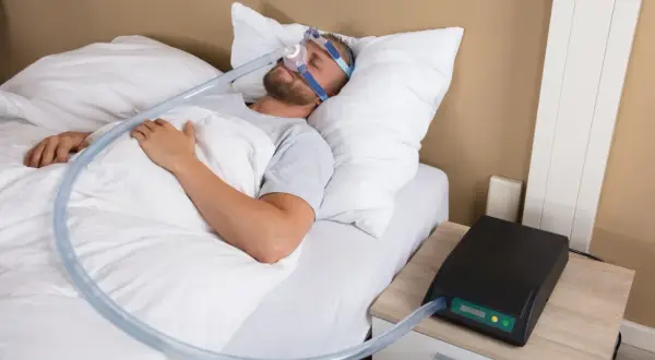 Man sover med CPAP-mask för att motverka snarkning. En bettskena kan också vara ett alternativ.