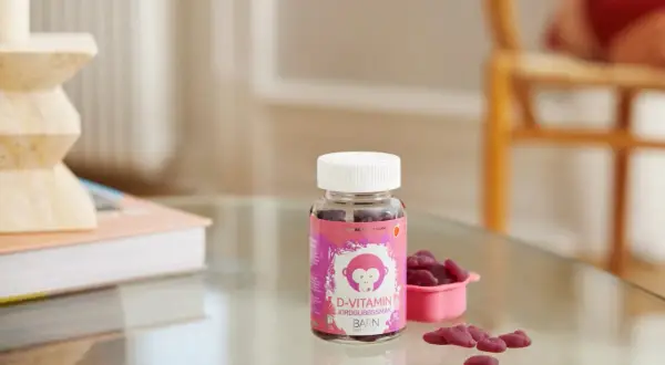 D-vitamin jordgubbssmak för barn, perfekt för vintermörkret. En flaska med björnsformade geléhallon och en liten rosa skål.