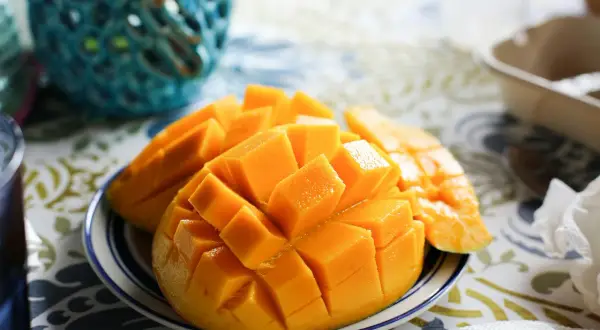 Skivad mango på en tallrik, en tropisk frukt rik på vitamin A.