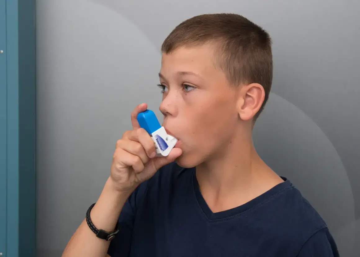 Pojke använder inhalator. Tänk på att vape farligt kan påverka lungorna.