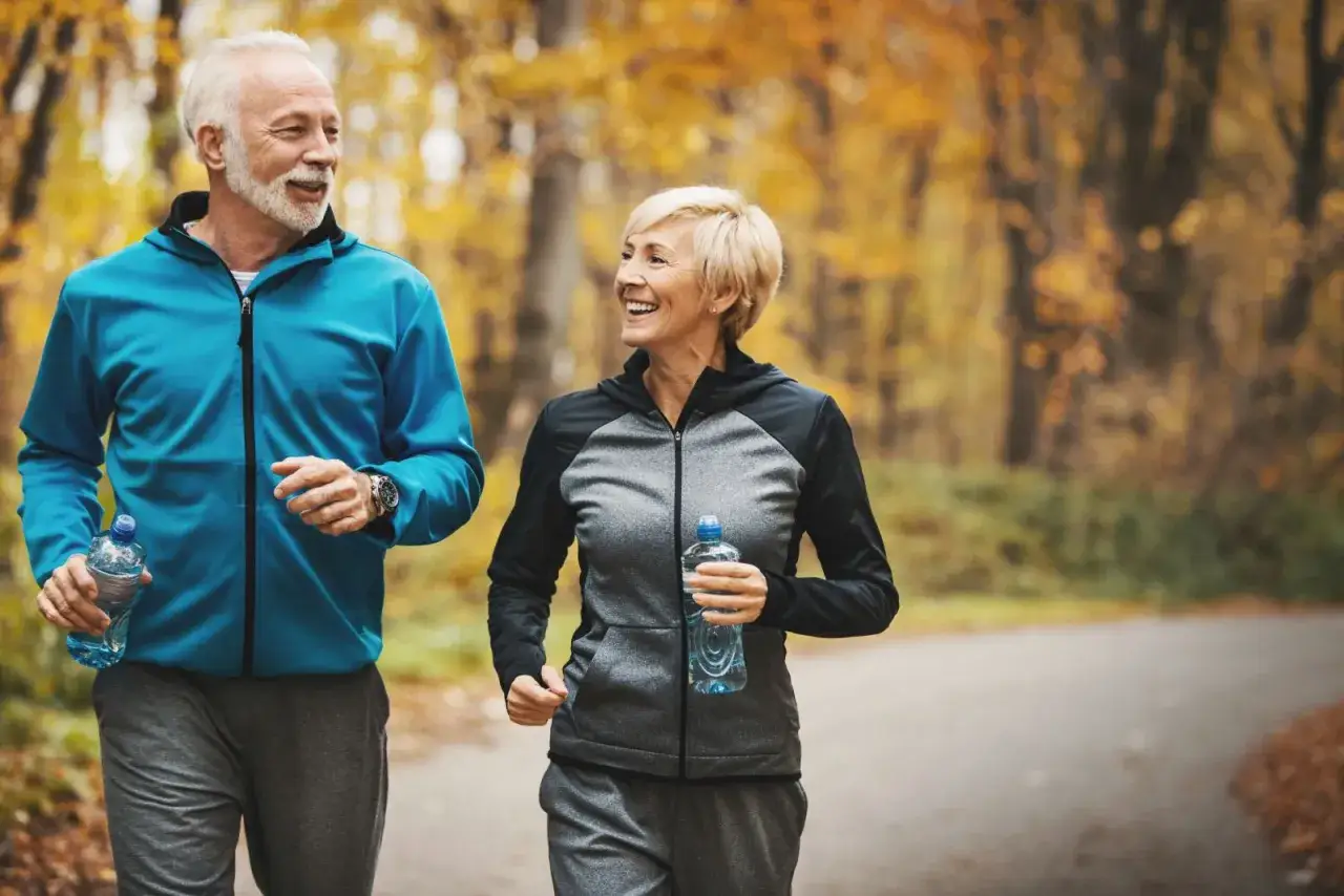 Ett glatt &auml;ldre par joggar i h&ouml;stskogen, ett tydligt svar p&aring; fr&aring;gan 