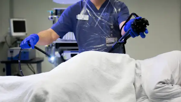 Läkare utför en endoskopi av tjocktarmen med ett flexibelt instrument.