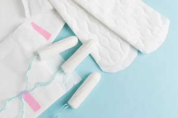 Hygienprodukter som bindor och tamponger, viktiga för kvinnor efter graviditet och under menstruation.