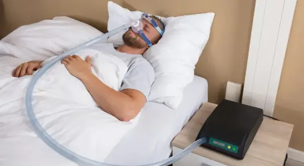 Man sover med CPAP-mask för att motverka snarkning. En bettskena kan också vara ett alternativ.