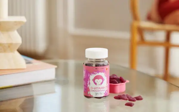 D-vitamin jordgubbssmak för barn, perfekt för vintermörkret. En flaska med björnsformade geléhallon och en liten rosa skål.